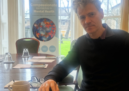 Arnaud Vallet with a compassionate mental health banner behind him