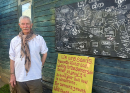 Barry stand in front of a map of Coed and a yellow board saying we are all seeds