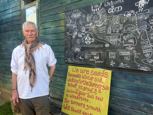BarryCoedMap Barry stand in front of a map of Coed and a yellow board saying we are all seeds